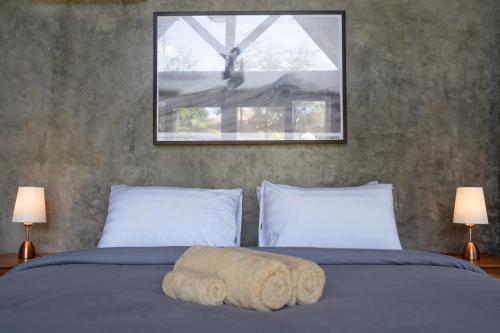 a bedroom with a bed with two pillows at Villa Amantes Bingin in Uluwatu