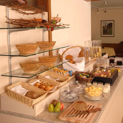 a buffet with many baskets of food on a counter at Hotel Viktoria-Leukerbad-Therme in Leukerbad
