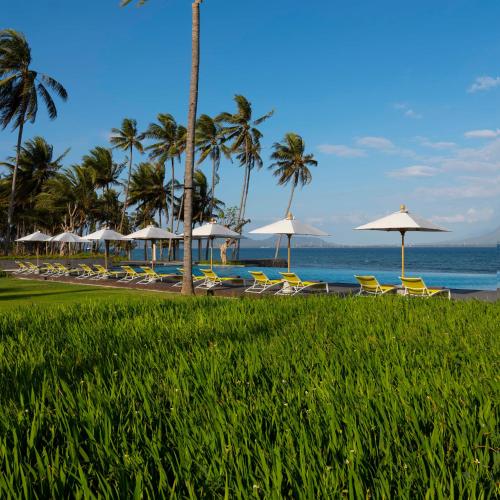 a beach with chairs and umbrellas and the ocean at Dialoog Banyuwangi in Banyuwangi
