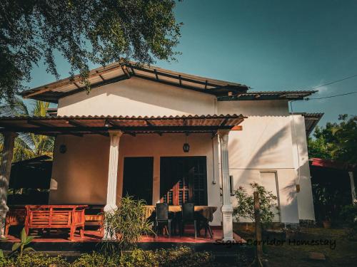 een klein wit huis met een tafel en stoelen bij Sigiri Corridor Home Stay in Sigiriya