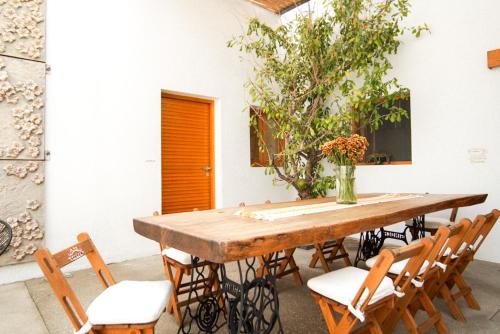 a wooden table with chairs and a vase of flowers at Casa Carmen Morelos in Oaxaca City