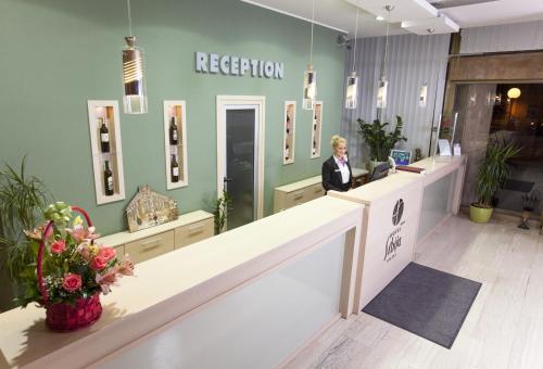 a woman standing at a reception desk in a store at Hotel Srbija in Vršac