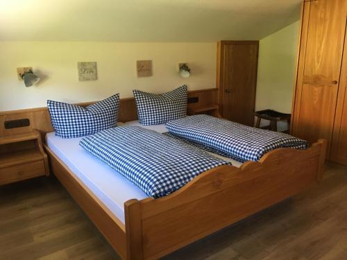 een slaapkamer met 2 bedden met blauwe en witte kussens bij Pension Hilde Ferienwohnung in Sulzberg