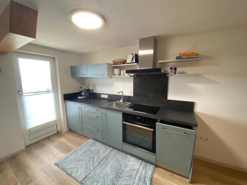 een keuken met een wastafel en een fornuis top oven bij Pension Hilde Ferienwohnung in Sulzberg