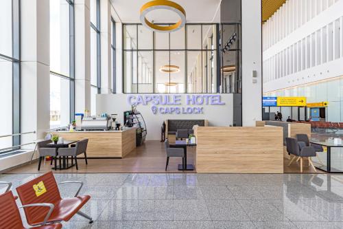 a lobby of a hotel with tables and chairs at CAPS LOCK Airport Hotel in Astana