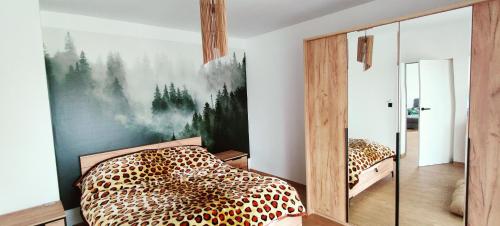 een slaapkamer met een bed met luipaardprint en een spiegel bij Ranczo Bosikowo in Kłyżówka