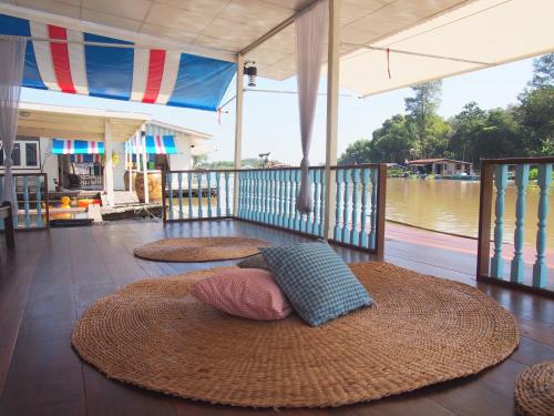 a room with two large straw mats on a floor with a river at อยู่แพ PaeStay อุทัยธานี in Uthai Thani
