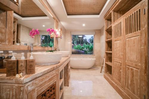 a bathroom with two sinks and a tub at Weda Cita Resort and Spa by Mahaputra in Ubud