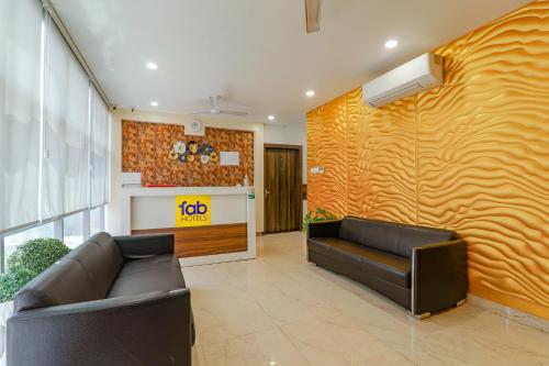eine Lobby mit einem Sofa und einer gelben Wand in der Unterkunft FabExpress The Mall Inn in Kānpur