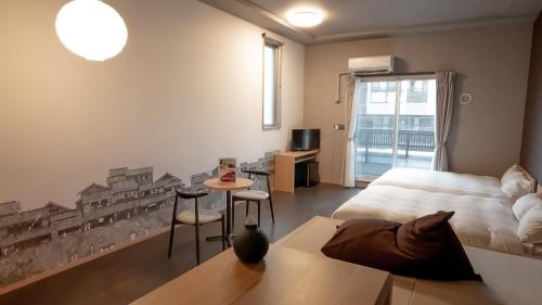 a bedroom with a bed and a table and chairs at Rakuten STAY Hakata Gion 302 - Rakuten Ichiba Collaboration Room - in Fukuoka