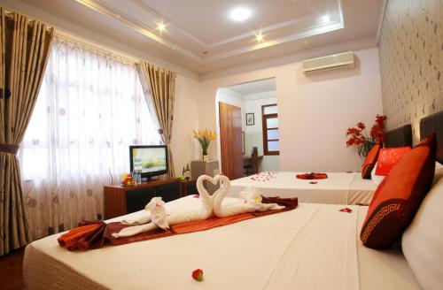a hotel room with two beds with swans on them at Urban Alley Hotel in Hanoi