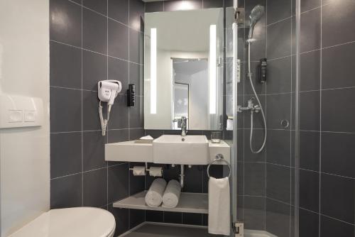 a bathroom with a sink and a shower and a toilet at ibis Bengaluru Hebbal - An Accor Brand in Bangalore