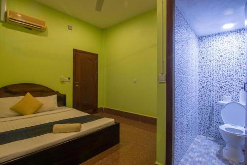 a bedroom with a bed and a bathroom with a toilet at Relax Resort Angkor Villa in Siem Reap