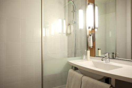 La salle de bains est pourvue d'un lavabo et d'une douche. dans l'établissement ibis Biarritz Anglet Aéroport, à Anglet