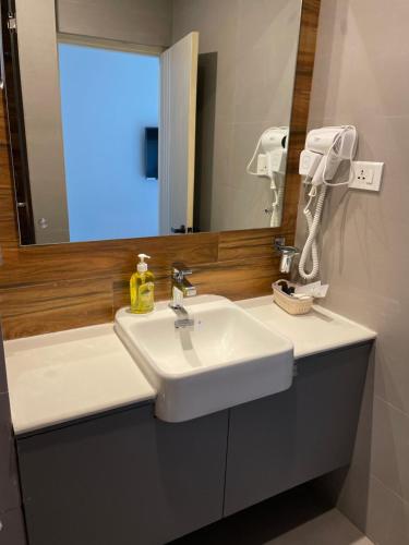 a bathroom with a white sink and a mirror at Palmo Holiday Apartments in Kathmandu
