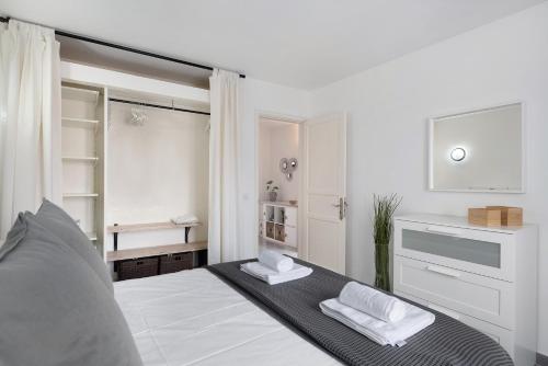 una camera da letto con un letto bianco e asciugamani di Casa Paloma a Costa Teguise