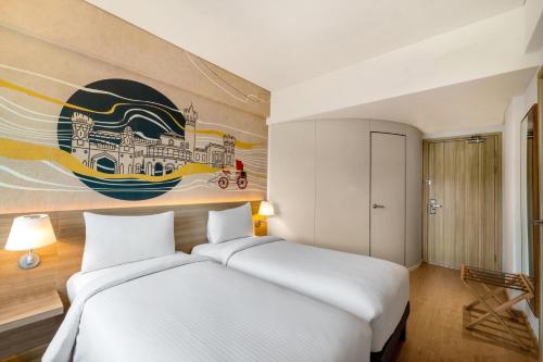 two beds in a room with a painting on the wall at ibis Bengaluru Hebbal - An Accor Brand in Bengaluru