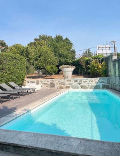 a swimming pool with blue water in a yard at CASA CAMPO DA FEIRA in Felgueiras