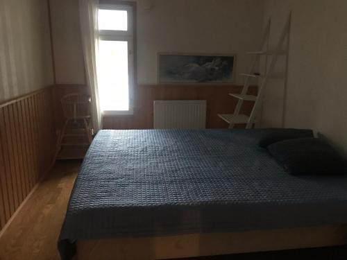 een slaapkamer met een bed met een blauw dekbed en een raam bij Kaaro 2 Cottage in Hillosensalmi