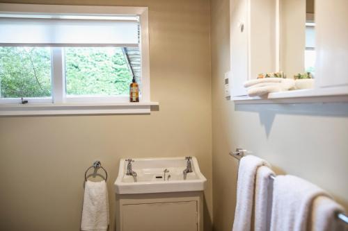 ein Bad mit einem Waschbecken, einem Fenster und Handtüchern in der Unterkunft Washpen Falls in Windwhistle
