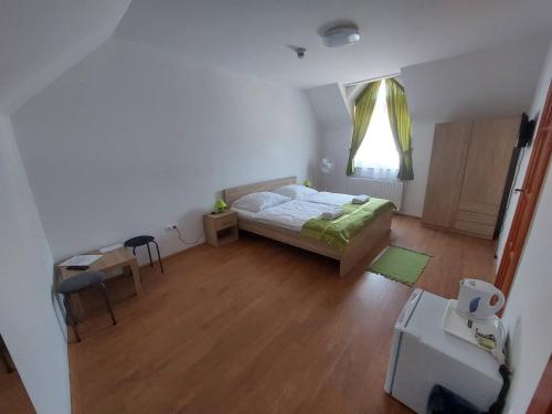 1 dormitorio con cama, mesa y ventana en Csipke Vendégház, en Orfű