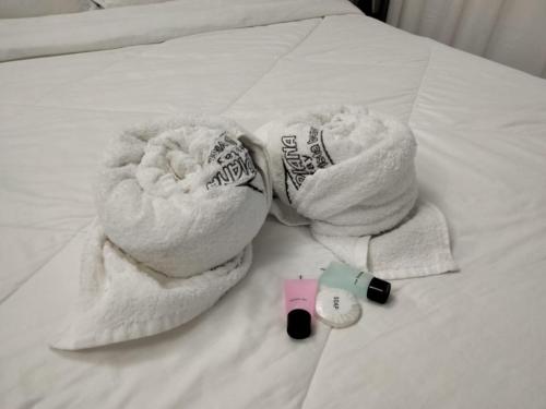 a pair of towels on a bed with a alarm clock at D’Impiana Homestay @Vista Bangi in Kajang