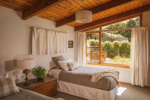 ein Schlafzimmer mit einem Bett und einem großen Fenster in der Unterkunft Washpen Falls in Windwhistle