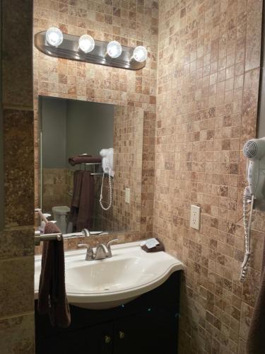 a bathroom with a sink and a mirror at Plaza Inn in Sabetha