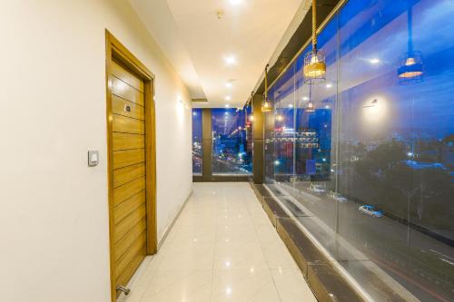 a hallway with a door and a window at The Glory Hotel in Dehradun
