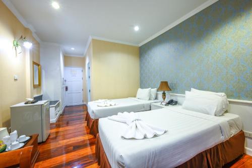 a hotel room with two beds and a bathroom at Chateau de Khaoyai Hotel & Resort in Khao Yai