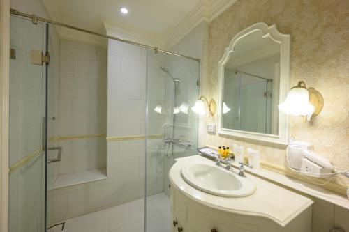 a bathroom with a shower and a sink and a mirror at Chateau de Khaoyai Hotel & Resort in Khao Yai