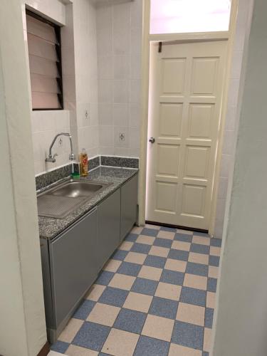 a kitchen with a sink and a white door at Afamosa Dsavoy Condotel in Kampong Alor Gajah
