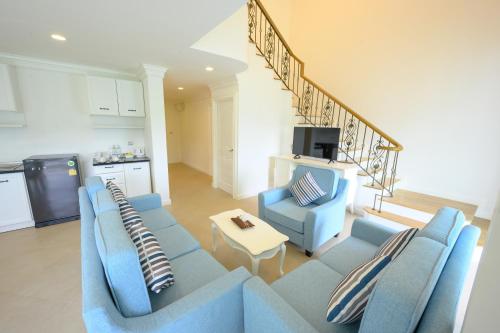 a living room with a blue couch and two chairs at Chateau de Khaoyai Hotel & Resort in Khao Yai