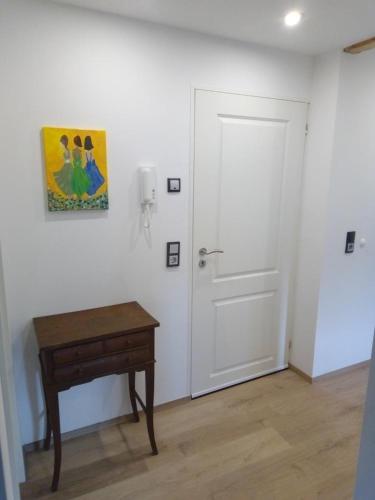 a white room with a door and a wooden table at Ferienwohnung im roten Haus, die Therme ist fußläufig in 350m zu erreichen in Bad Ems