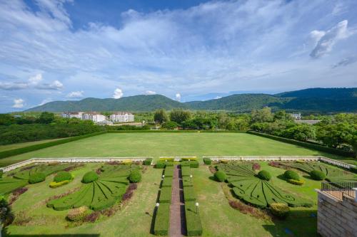 an aerial view of a large green field with mountains at Chateau de Khaoyai Hotel & Resort in Khao Yai