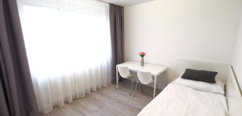 1 dormitorio con cama, mesa y ventana en Marilyn príjemný 3 izbový byt v Rači, en Rača