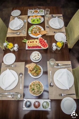 a wooden table with plates of food on it at Hotel Abigail Goradia's in Shirdi