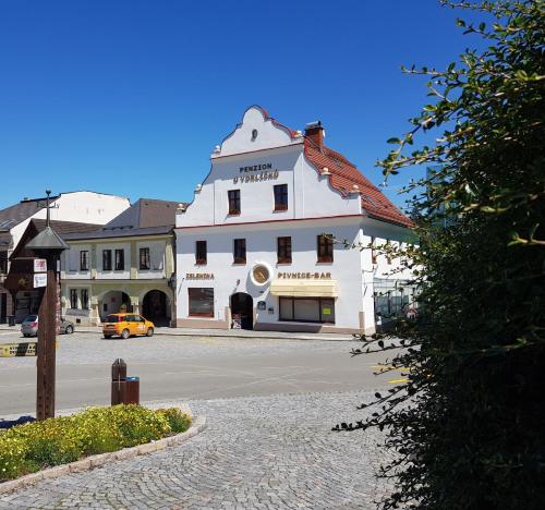 a large white building on the side of a street at Penzion U Vorlíčků in Jablonné nad Orlicí