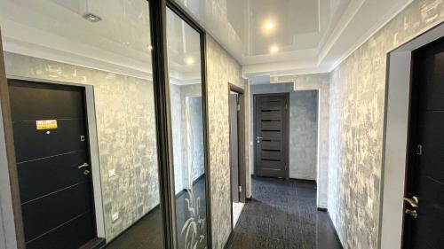 a hallway with a black door and a wall with graffiti at Двокімнатна на Оболоні біля Дрім-Тауна in Kyiv