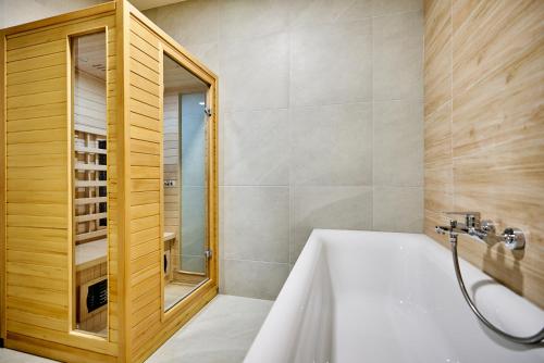 uma casa de banho com uma banheira branca e um chuveiro em RUPE Jáchymov em Jáchymov