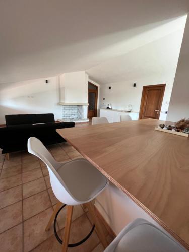 a kitchen with a wooden table and a white chair at B-Guest House in Oristano