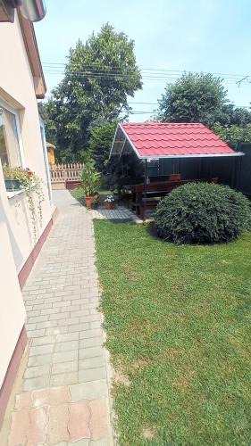 a house with a red roof and a walkway at Bagolylak Vendégház Siófok in Siófok