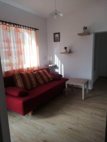 a living room with a red couch and a table at Bagolylak Vendégház Siófok in Siófok
