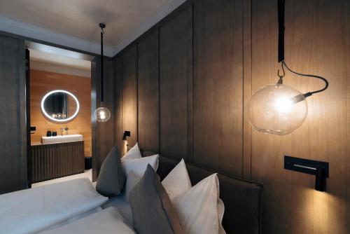 a bedroom with a bed and a lamp and a mirror at Andermatt Alpine Apartments in Andermatt
