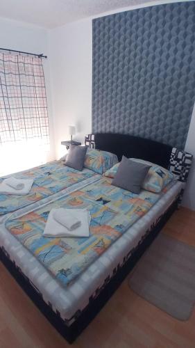 a bedroom with a large bed with a large headboard at Bagolylak Vendégház Siófok in Siófok
