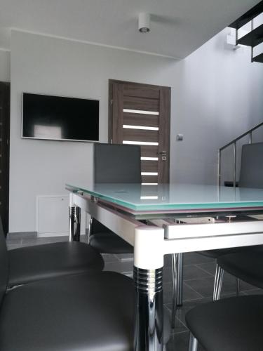 a ping pong table in a room with chairs at Całoroczne domy do wynajęcia in Narty