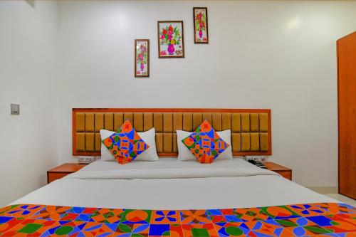 インドールにあるFabHotel Day2Dayのベッドルーム1室(大型ベッド1台、カラフルな枕付)