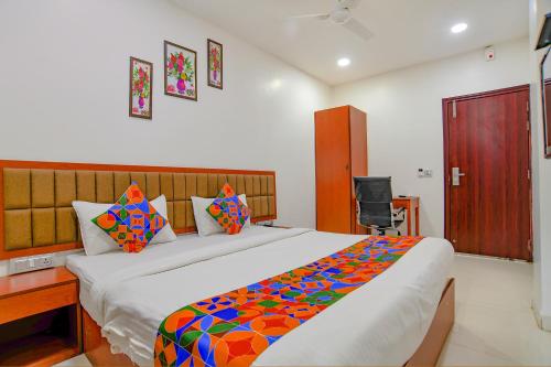 1 dormitorio con 1 cama grande con una manta colorida en FabHotel Day2Day, en Indore