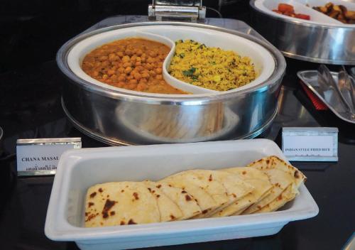 a tray of food with chapati and a plate of food at Kingston Suites Bangkok in Bangkok