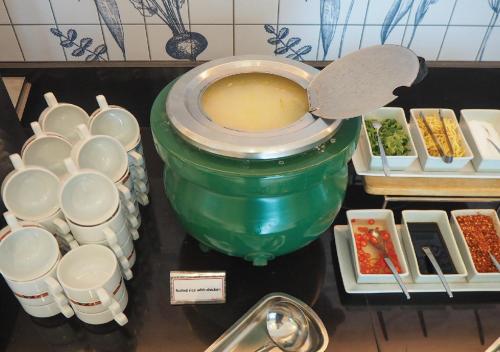 a large green pot with a bowl on top of it at Kingston Suites Bangkok in Bangkok